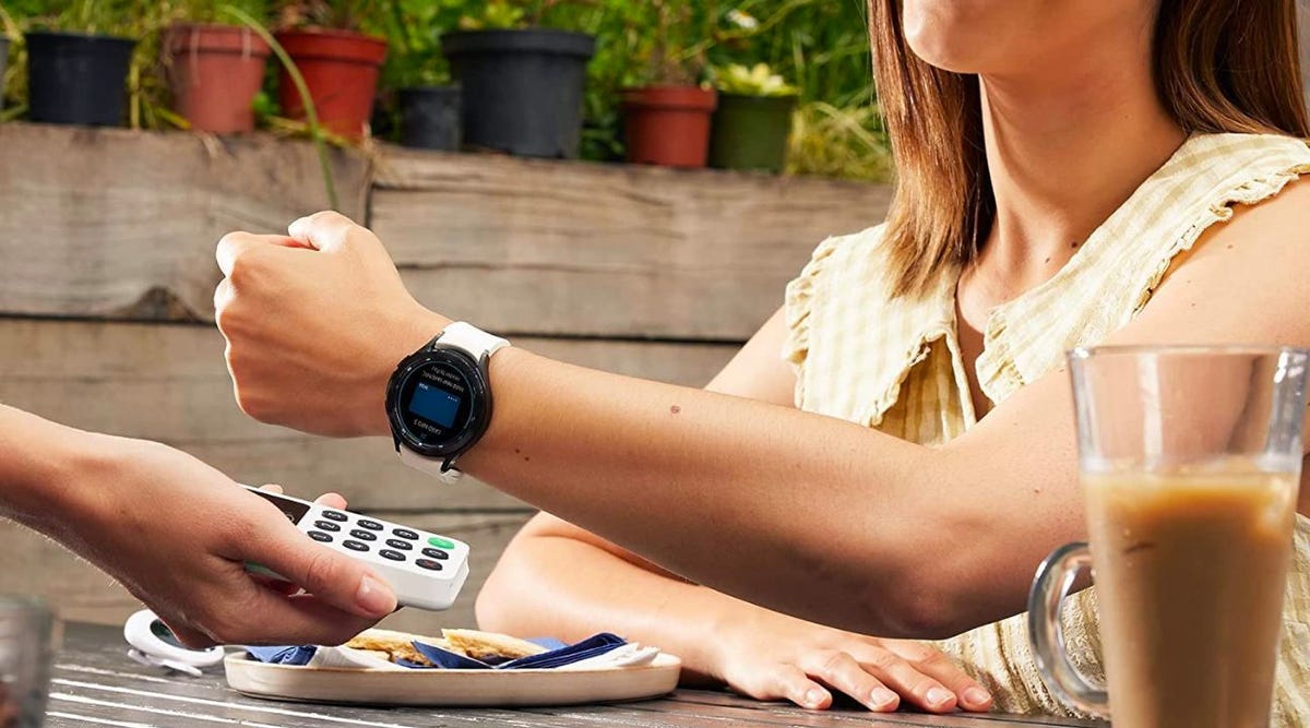 Woman uses her Samsung Galaxy Watch 4 Classic to pay for her meal.