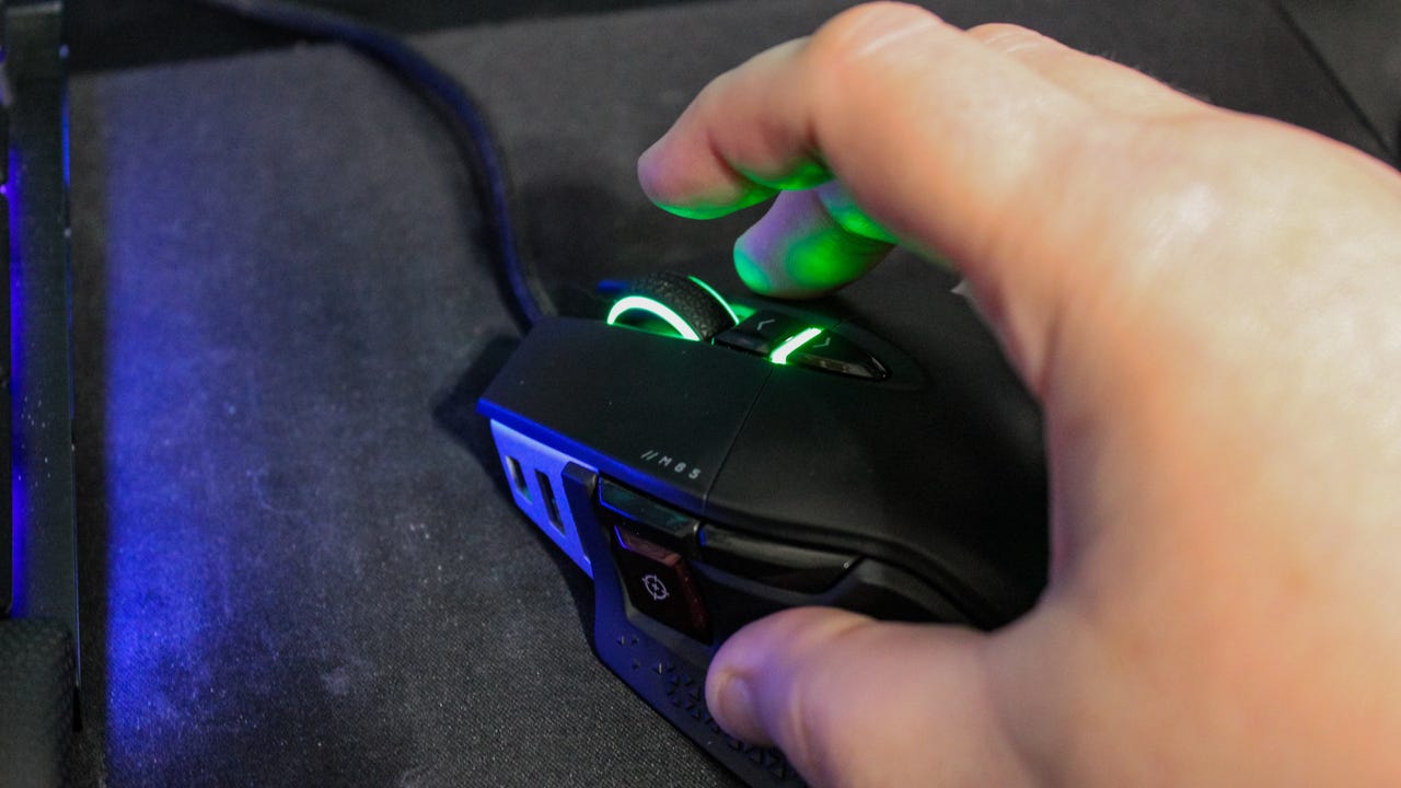 A Corsair M65 RGB Ultra wired mouse being used in a fingertip style grip.