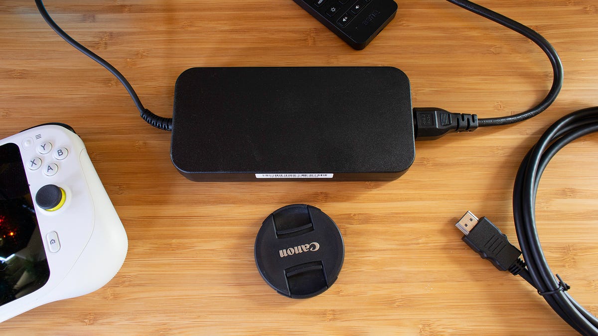 The included power adapter in BenQ Mobiuz gaming monitor with some objects around for scale