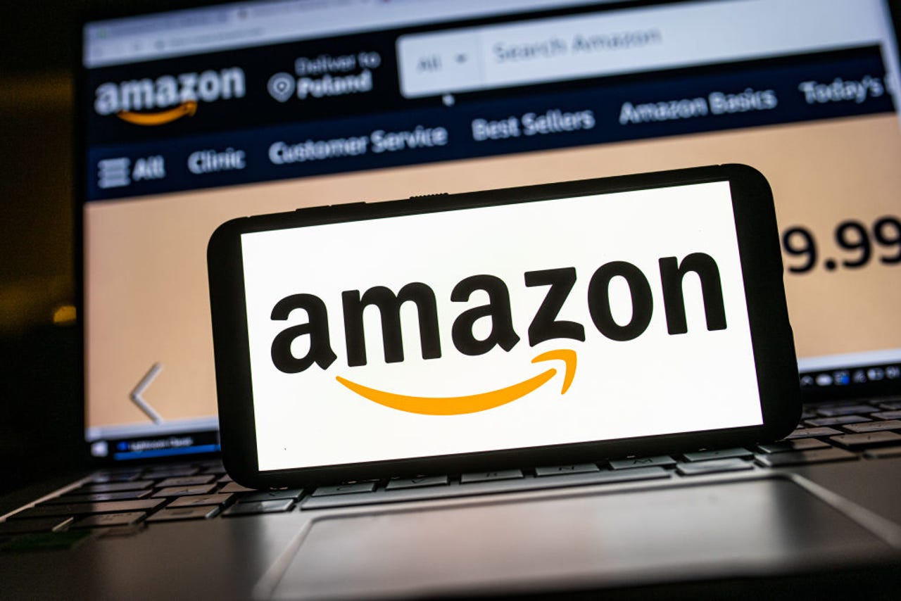 Amazon logo on phone with background of Amazon website