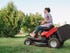 Person using a riding mower to cut grass
