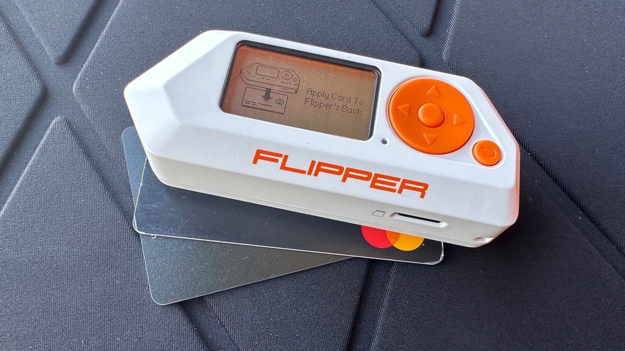 Flipper Zero with blocked readout, on top of credit card on top of Vulkit card.