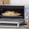 Stainless steel toaster oven on a counter and open with cooked food inside
