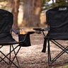 Two Coleman camping chairs sitting side-by-side in the woods