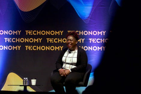 Kimberly Bryant smiles on stage of a techonomy conference
