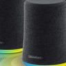 Two black Bluetooth speakers against a gradient blue and yellow background