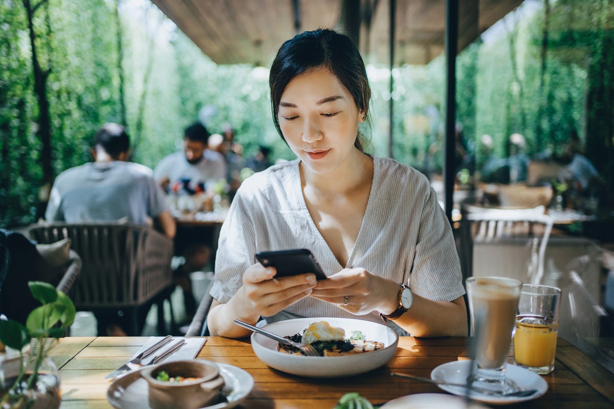 a-woman-using-her-smartphone-at-a-restaurant