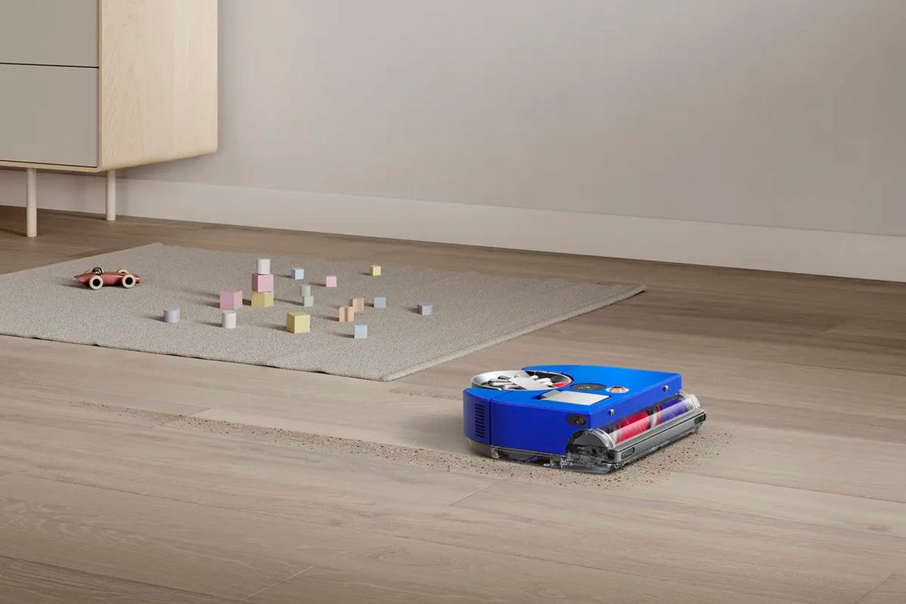 The Dyson 360 Vis Nav cleaning a hardwood floor with toys in the background