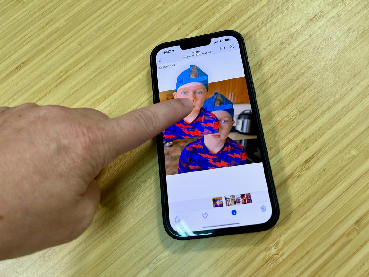 Finger moving a copy of a boy's figure out of a photo on an iPhone