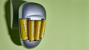 The process of charging AA-type Ni-Cd batteries in a charger connected to an outlet.