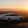 Lucid Air driving by a sunset.