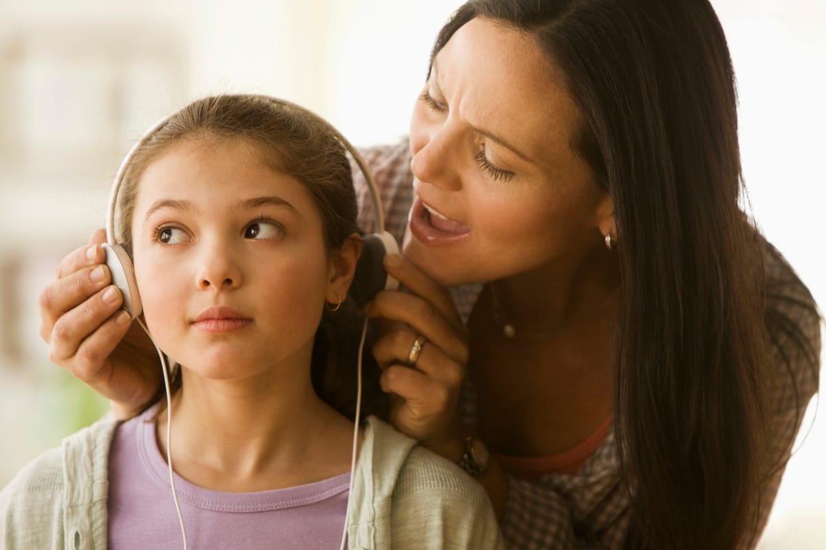 Woman removes headphones from child Image credit: Getty
