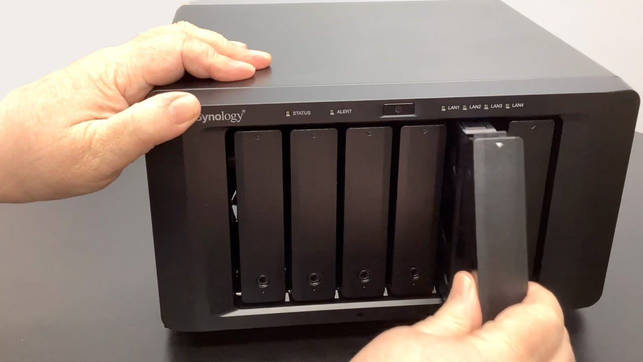 Hands holding 6-bay Synology 1621+ NAS