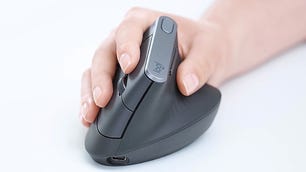Mão de uma pessoa segurando um mouse ergonômico preto