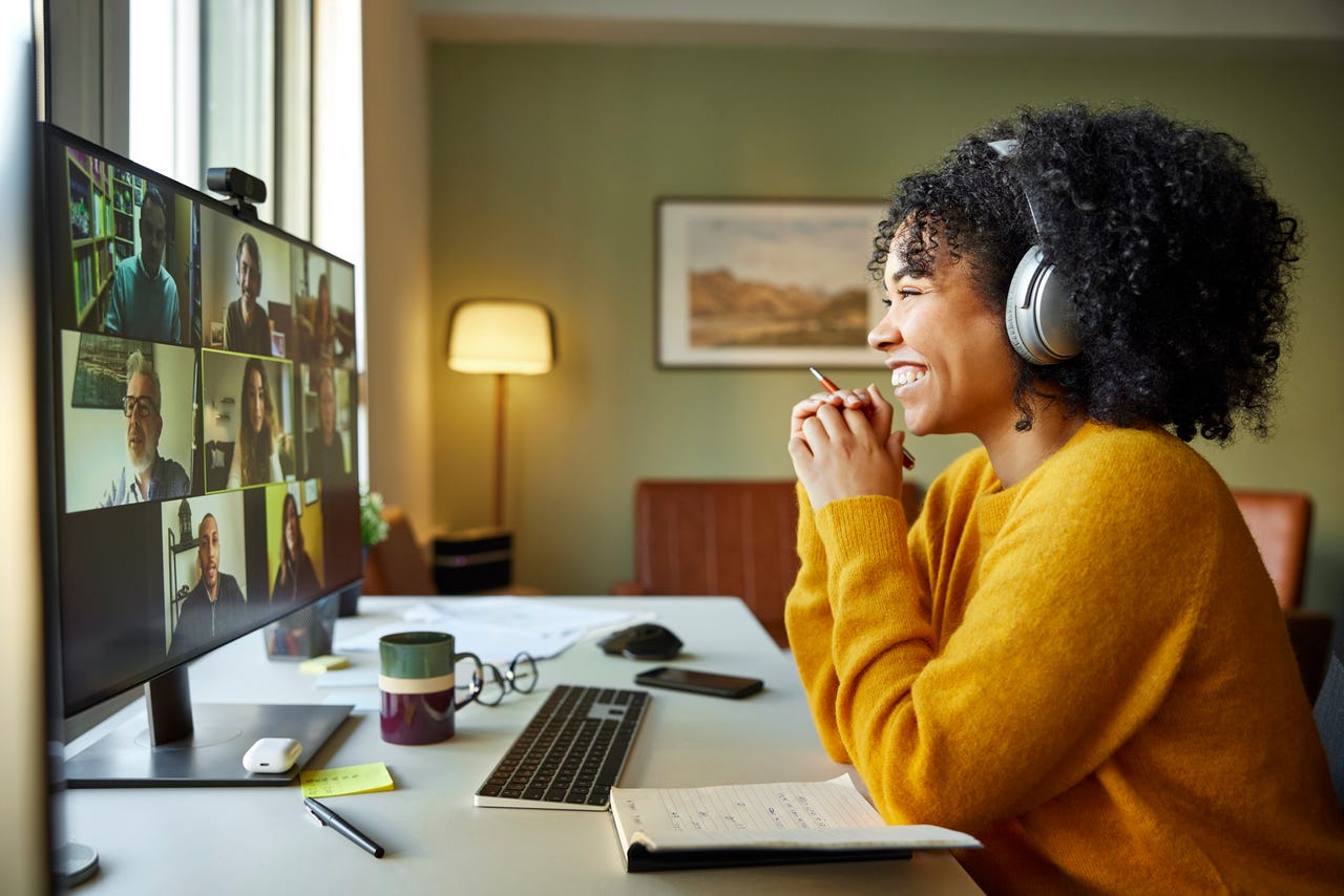 Businesswoman with headphones smiling during video conference.