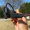Philips Go A7607 bone conduction headphones being held up in an outdoor setting