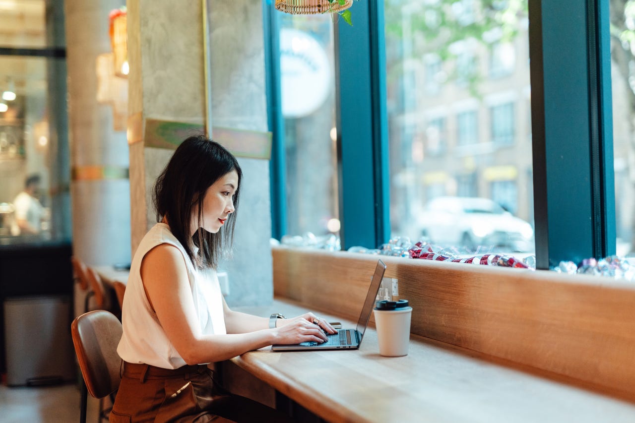 Woman working on laptop in coffee shop