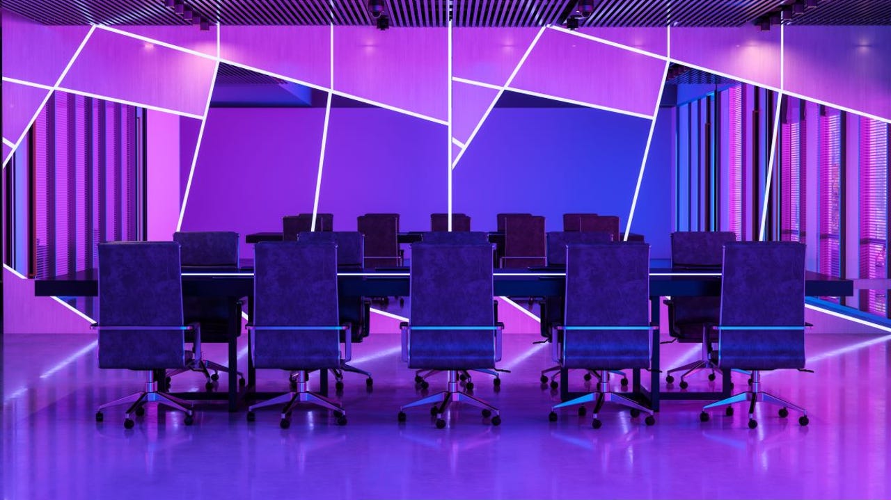 a row of desk chairs at a table in a futuristic office lit with neon purple, with mirrors in the background cut at irregular geometric shapes