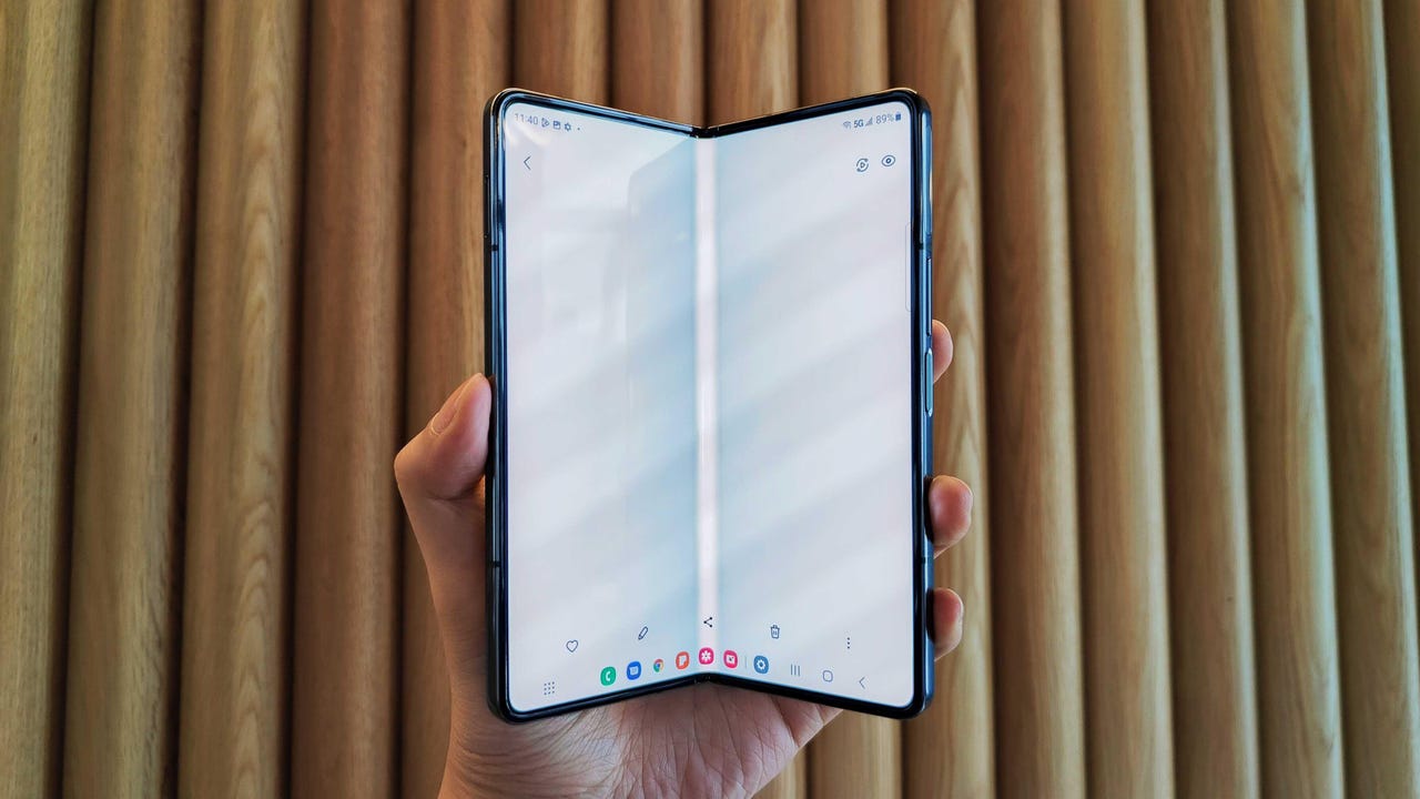 Hand folding the Samsung Galaxy Z Fold 4 showing the crease