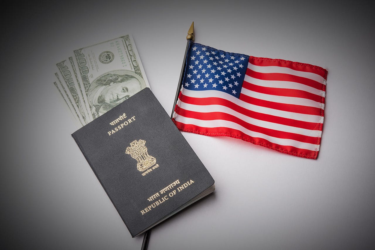 concept showing Indian passport with US currency notes or Dollars with american flag in the background, applying for US / american tourist or H-1B visa or travel visa
