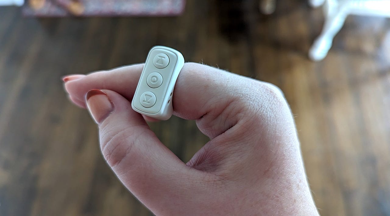 Person with a white wearable device around their index finger