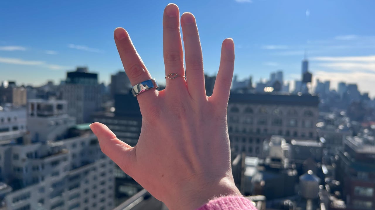 Oura Ring on hand against skyline