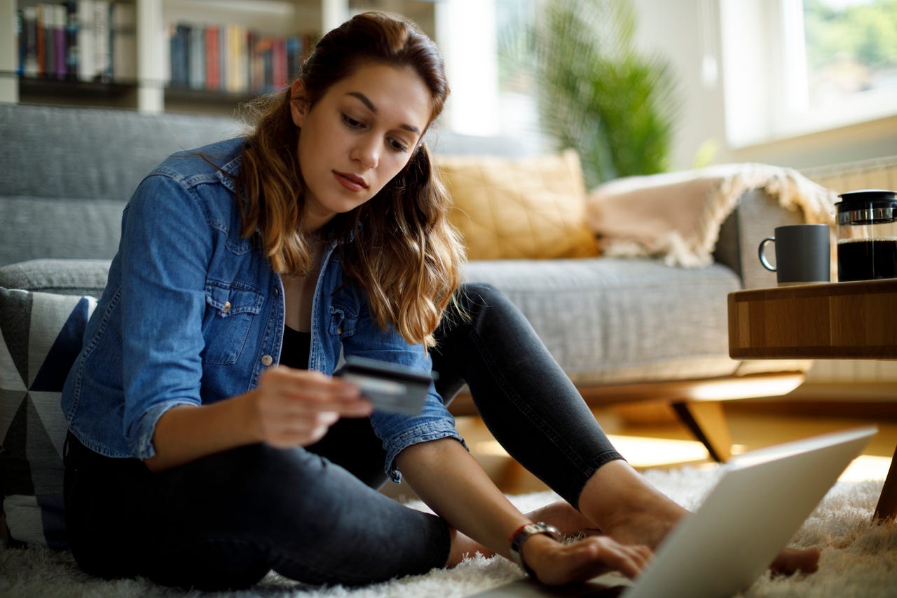a-woman-holding-her-bank-card-and-doing-online-shopping-from-home