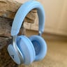 Soundcore Space One headphones in Sky Blue hanging from a brick corner