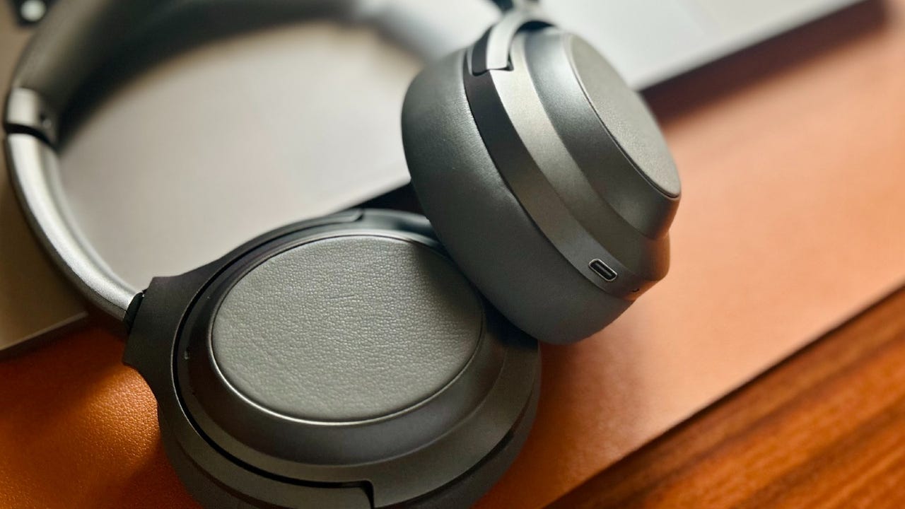 The Monoprice BT-600ANC headphones lying on a wood desk