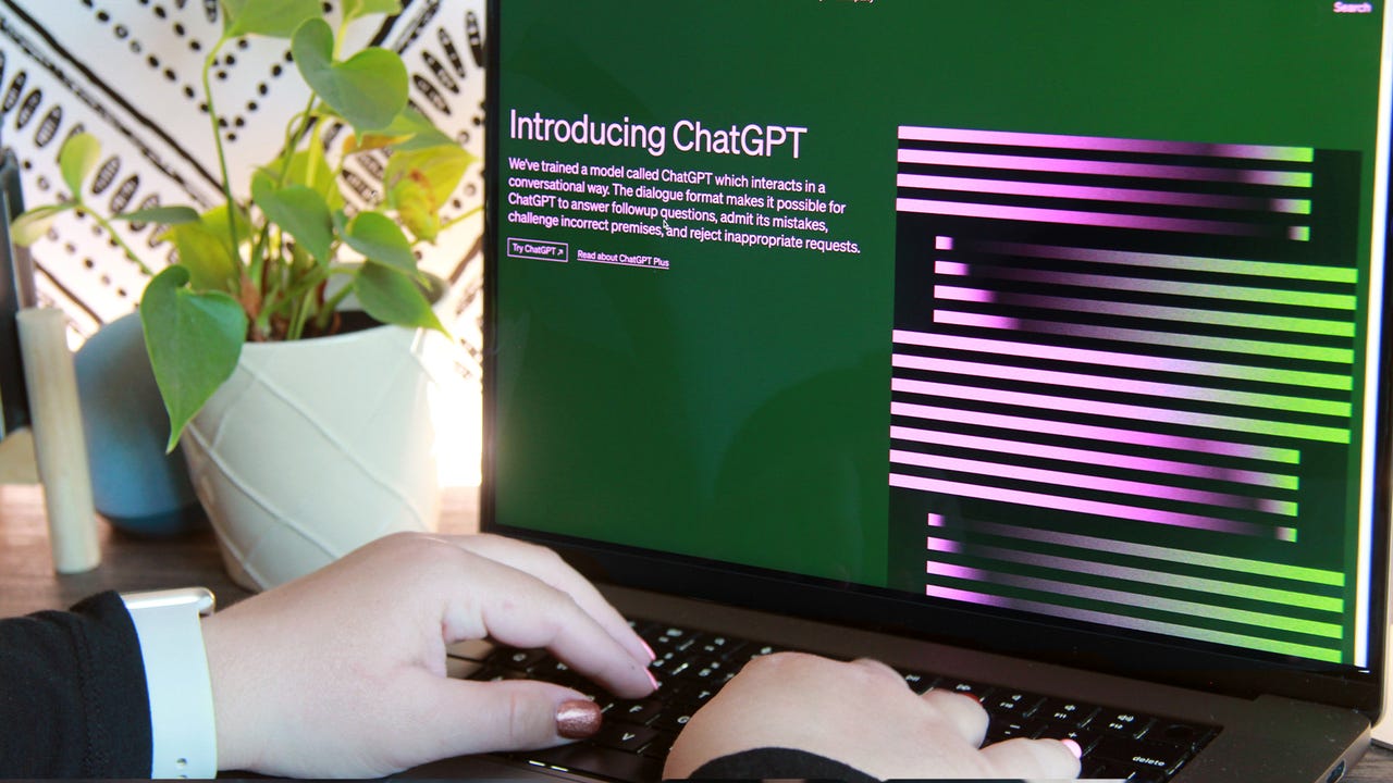 Hands typing on laptop with ChatGPT on the screen