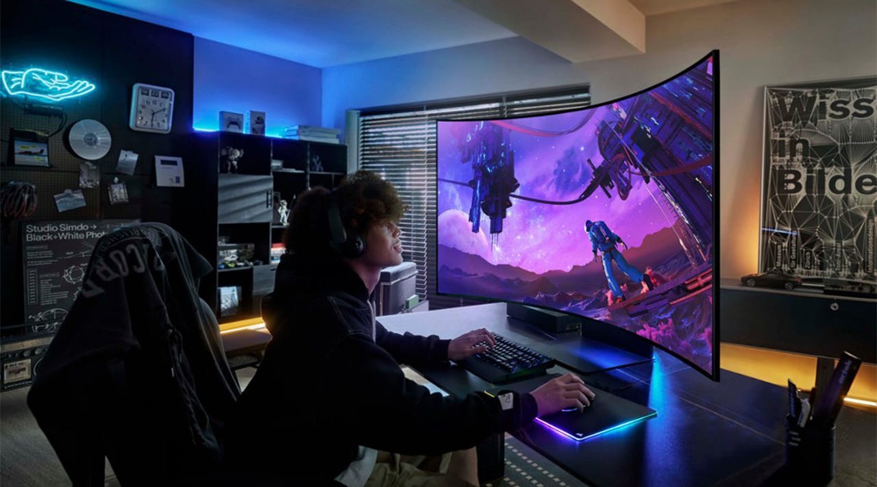 A young man using a Samsung Odyssey Ark monitor to play a game on his PC.