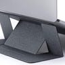 A minimalist gray laptop stand props up a Macbook laptop.