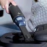 Small vacuum vacuuming a car cup holder