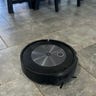 Roomba j7+ vacuuming on tile.