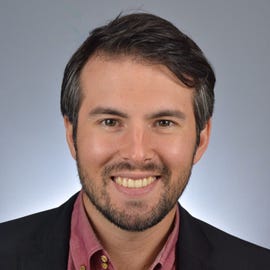 Phil Strazzulla, a man wearing business attire, smiles in a professional headshot.
