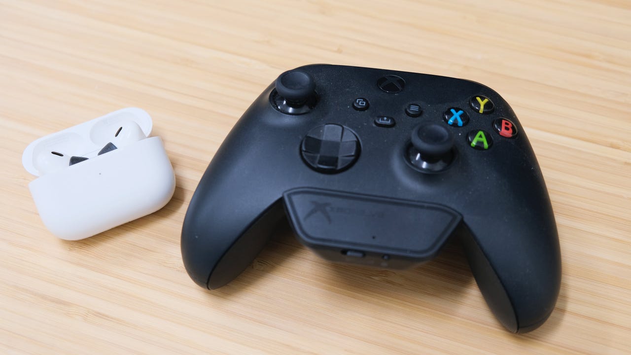 An Xbox controller with Bluetooth adapter and Apple AirPods