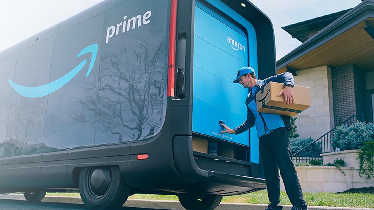 Amazon delivery driver closing a truck door and holding a package