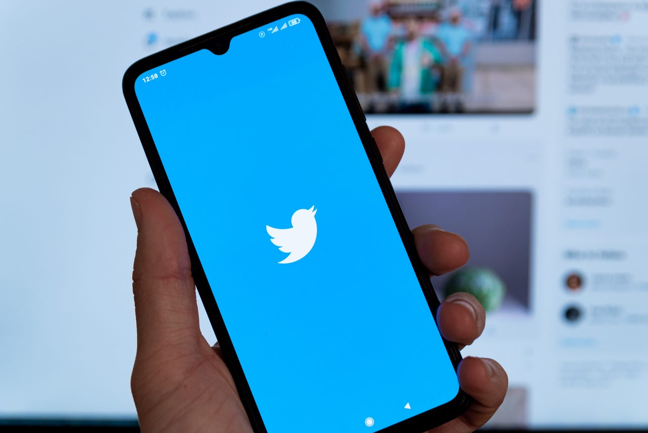 Phone showing Twitter's logo on a blurred background