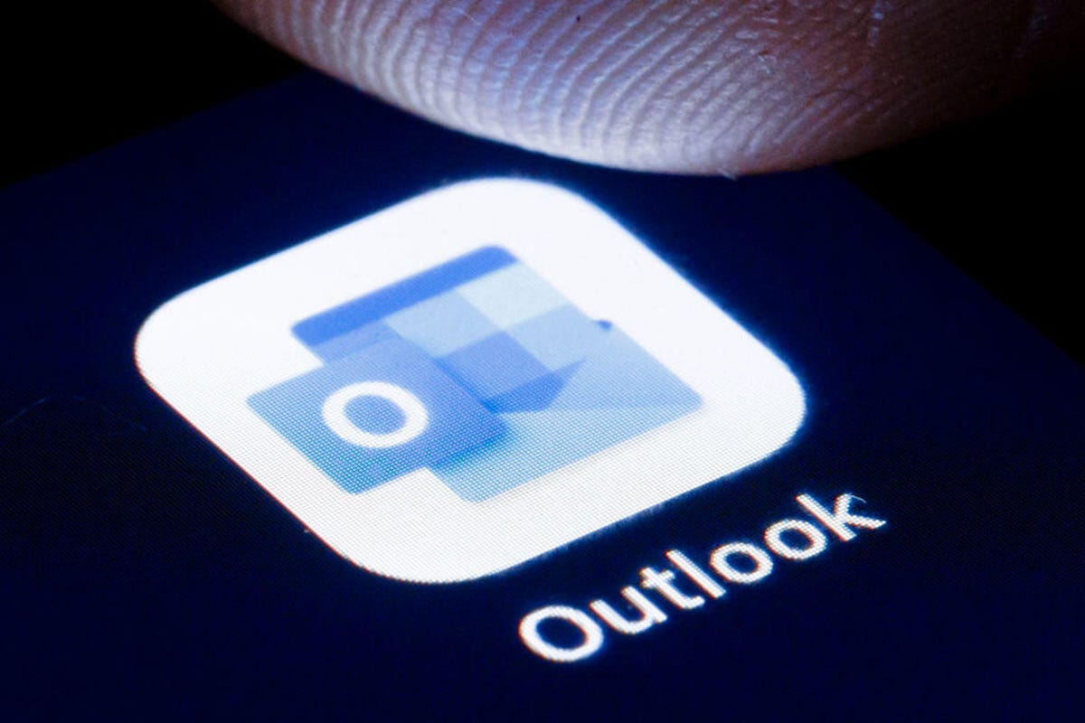 Outlook icon on the screen with a finger about to touch it.