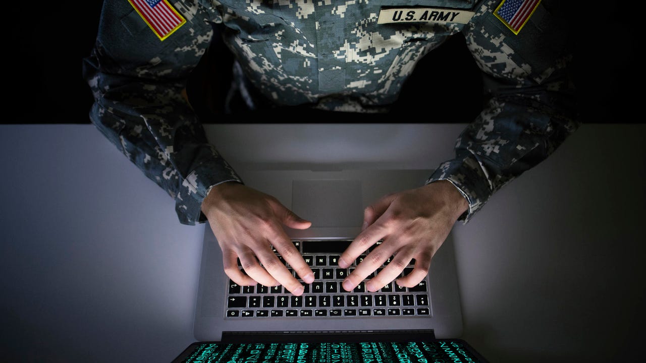 US military using a laptop for cyber warfare.