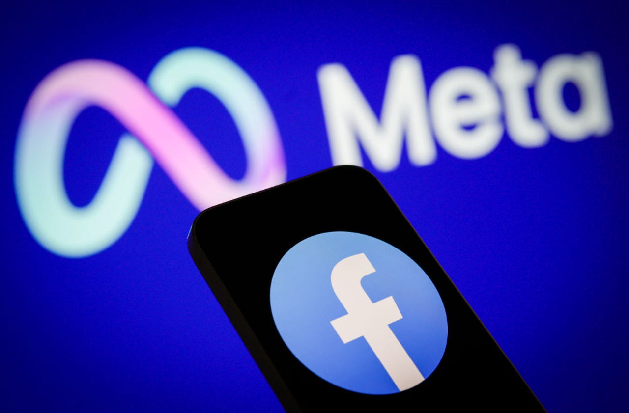Meta logo in background with Facebook logo on phone