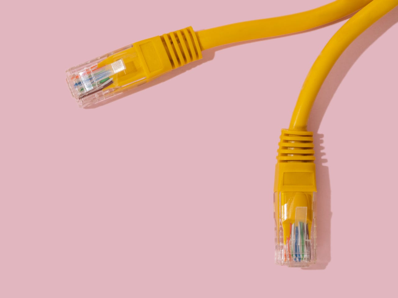 Yellow ethernet cable on pink background