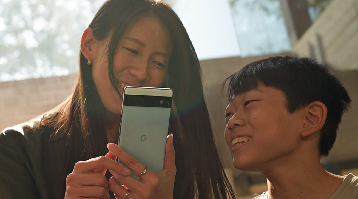 A woman setting up a Google Pixel 6A phone for a child.