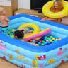 Family playing in an inflatable pool with balls in it