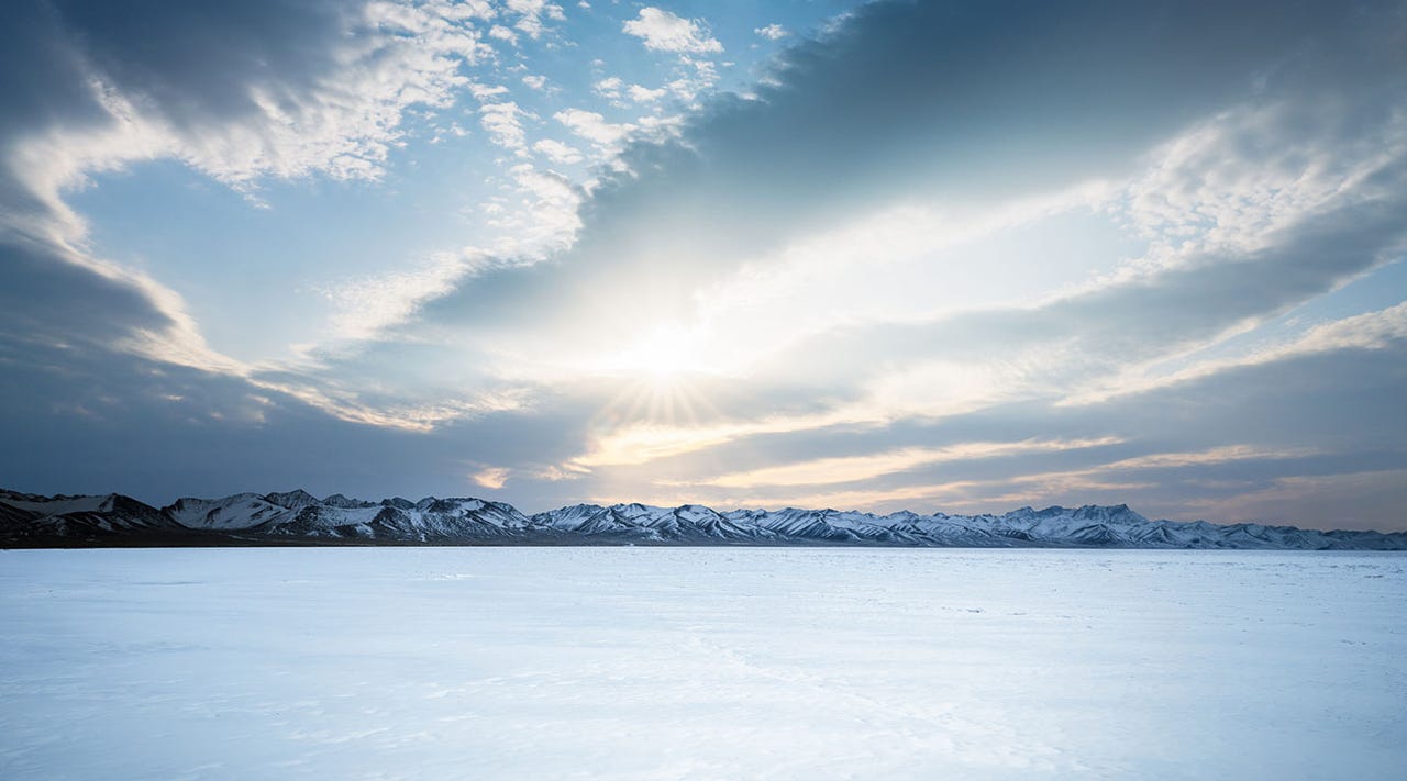 Frozen lake with sky and mountains