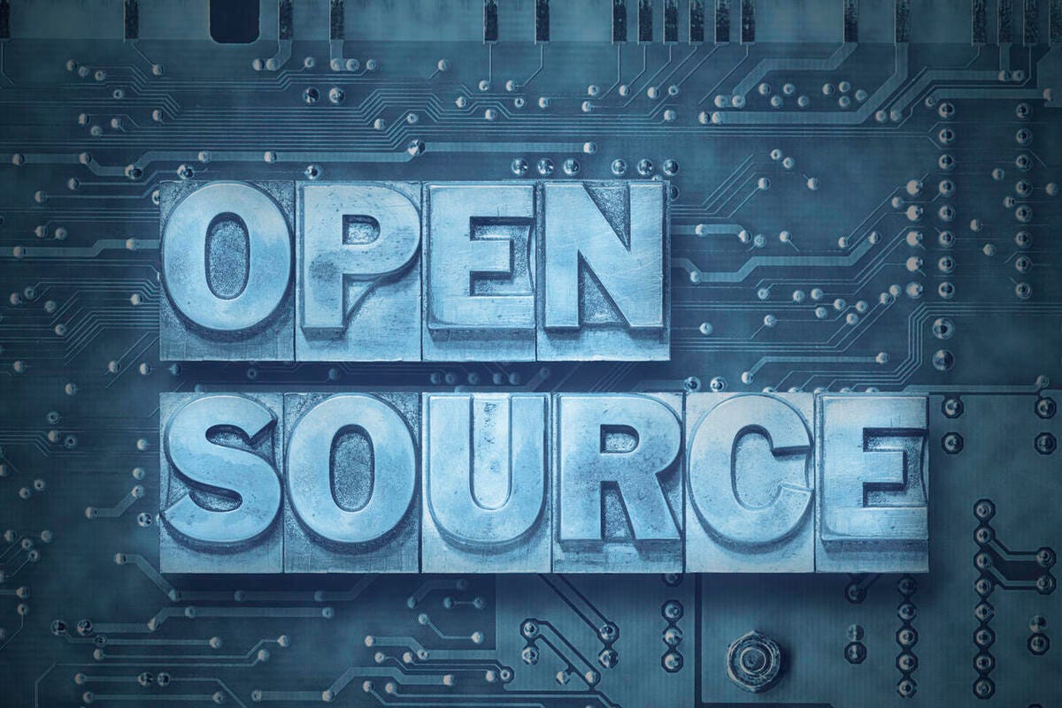 The words open source in metallic block letters on a PC board