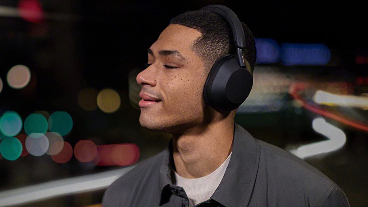A person wearing Sony WH-1000XM5 headphones.