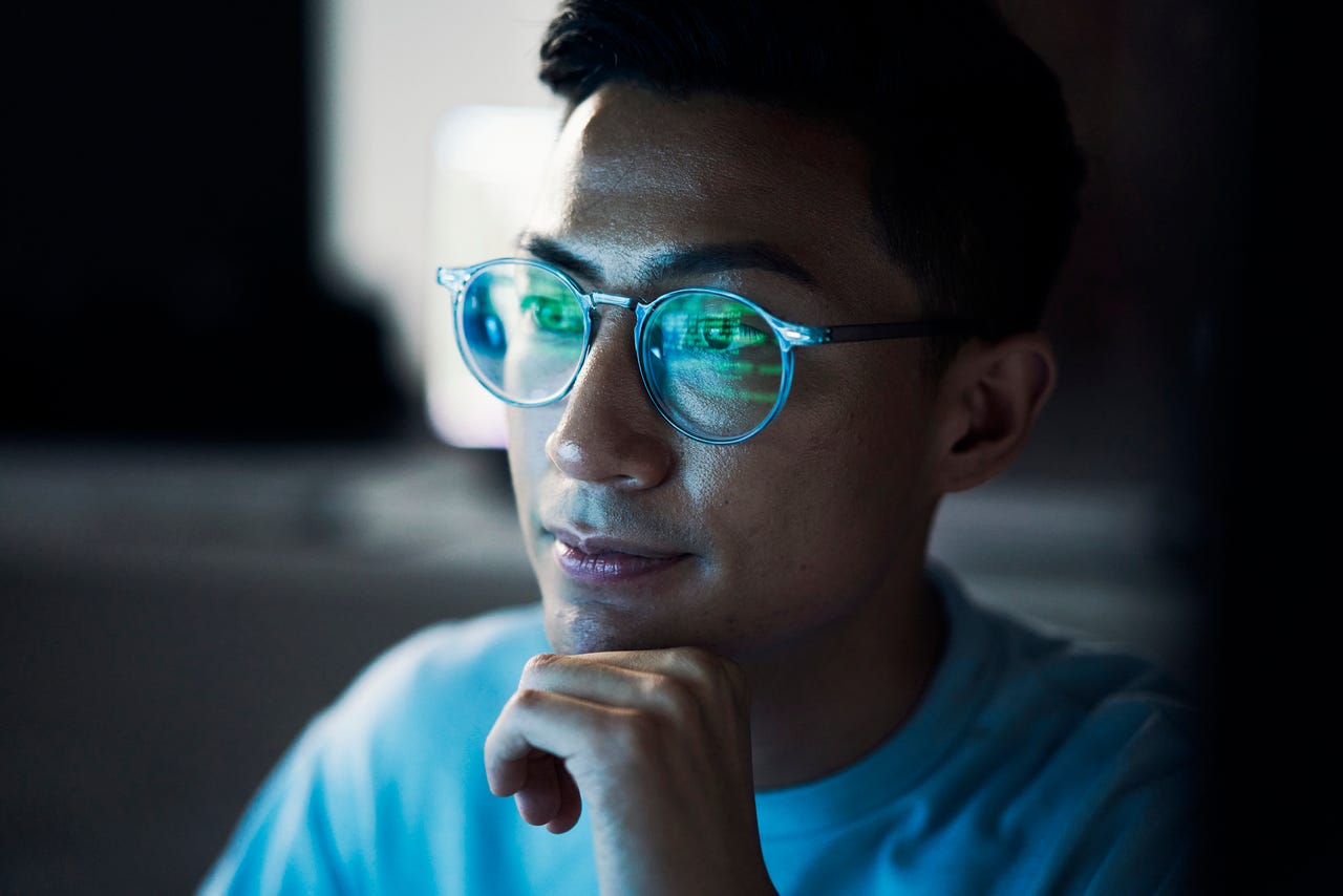 Man with code reflected in glasses