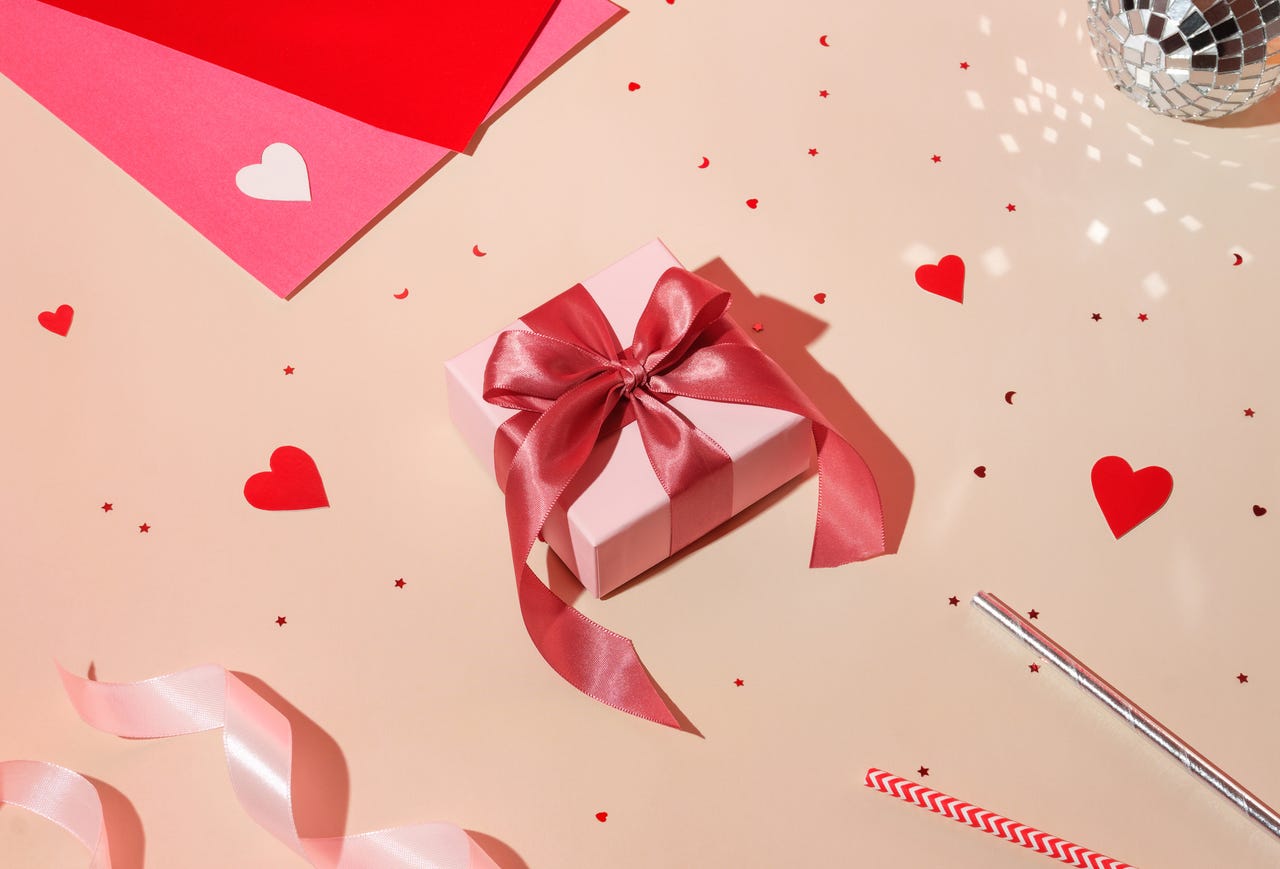 Caja de regalo con corazones y tarjetas salpicadas.