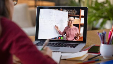 Student with glasses studying with video online lesson at home
